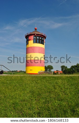 The Pilsum lighthouse in Krummhorn, Germany Royalty-Free Stock Photo #1806168133
