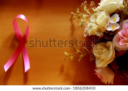 Ribbon on brown paper and brunch of flower  that show about  breast cancer awareness and encourage people On  picture can be use for text  and copy space.