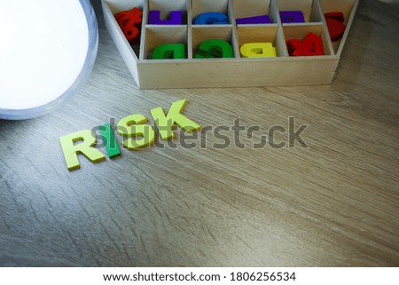 Block letters on risk with alphabets in boxes on wooden table 