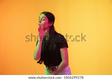 Caucasian young woman's portrait on yellow background