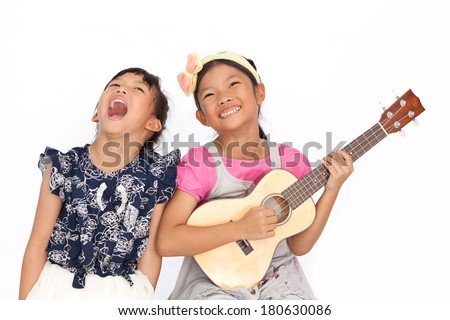 Little asian girls sing a song and playing ukulele isolate on white background Royalty-Free Stock Photo #180630086