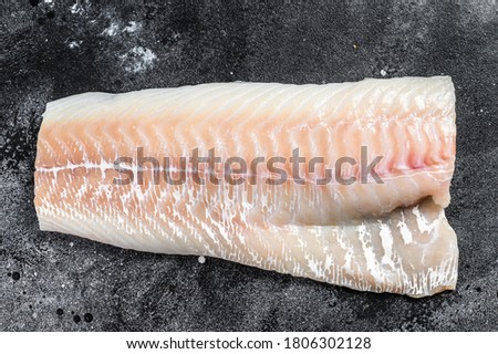 Raw Norwegian skrei cod fish fillet. Black background. Top view Royalty-Free Stock Photo #1806302128