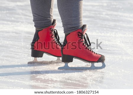 feet in red skates on an ice rink. hobbies and leisure. winter sports
