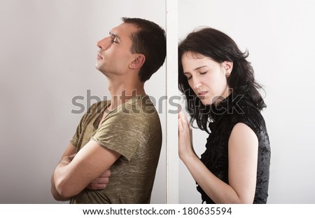 Conflict between man and woman standing on either side of a door Royalty-Free Stock Photo #180635594