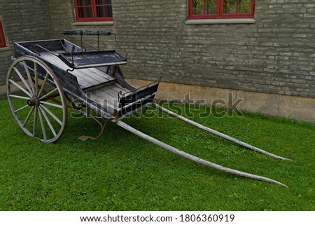 An old wooden two wheeled horse cart, used for transportation of goods and people.