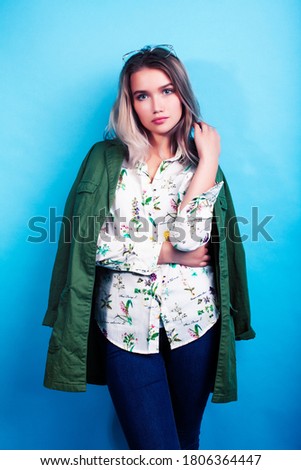 young pretty girl posing happy smiling on blue background, lifestyle people on summer vacation concept