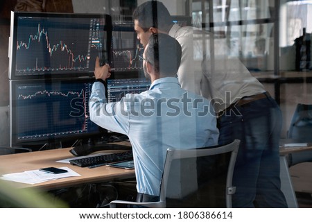 Two businessman working in office together, pointing at screen, discussion and checking global currency index on fund exchange Royalty-Free Stock Photo #1806386614