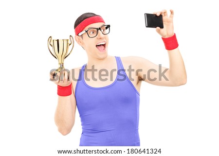 Male athlete taking picture of himself holding a trophy isolated on white background