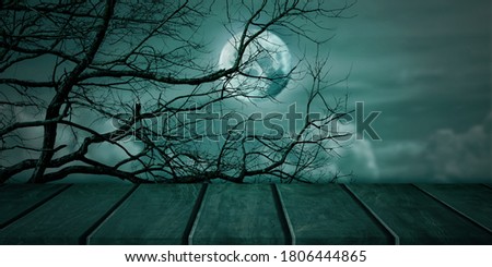 Halloween background. Spooky forest, Vintage wood tabletop with full moon sky. Copy space for text.