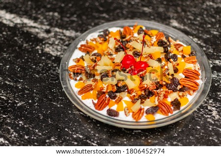 Dessert with nuts on textured table, very colorful isolated plate.