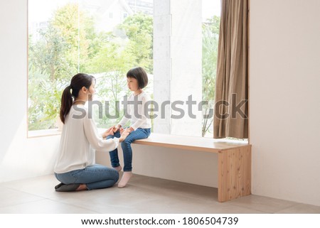 Mother comforting her daughter in the living room Royalty-Free Stock Photo #1806504739