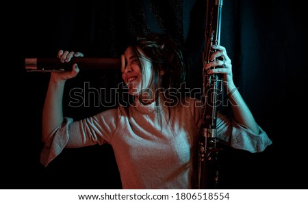 portrait of young woman playing with parts of a bassoon Royalty-Free Stock Photo #1806518554