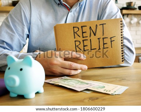 Rent relief. A man at home holds a handwritten lettering. Royalty-Free Stock Photo #1806600229