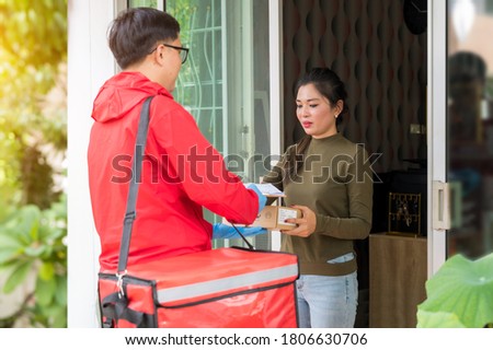 Asian woman receiving parcel from delivery man at home