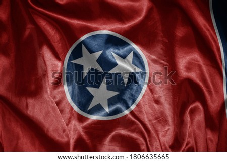 waving colorful shining big flag of tennessee state on a silky texture