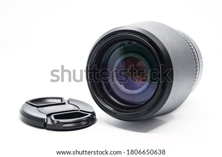 Close-up of black camera lens with cover removed isolated on white background. Photo equipment.