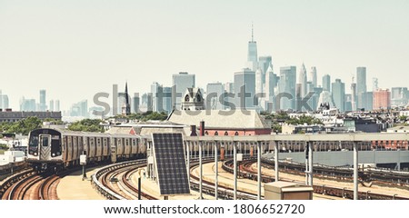 New York subway train with Manhattan skyline in background, color toned picture, USA.