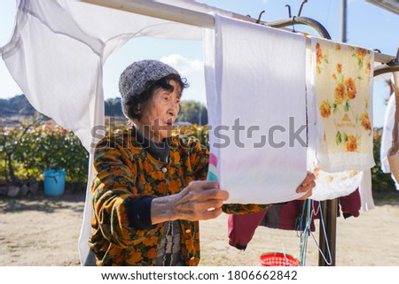 Senior woman with smile washing clothes