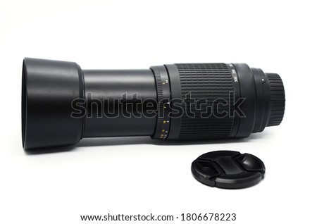 Close-up of black telephoto camera lens with cover removed isolated on white background. Photo equipment.