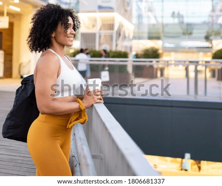 pretty woman with afro hair, outside of a shopping mall
