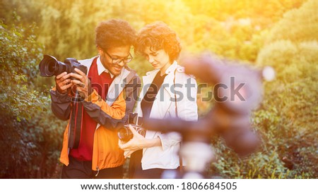 Photographer team with SLR camera and medium format camera taking pictures in nature