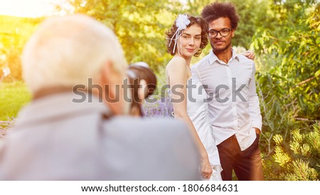 Photographer photographing a wedding with bride and groom in nature
