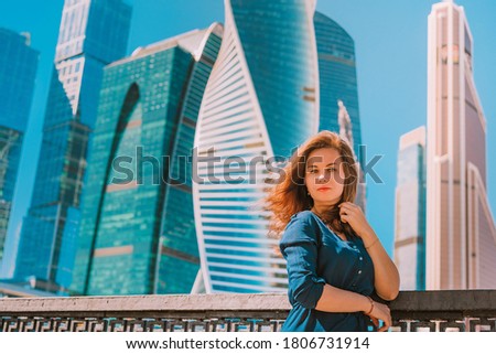 Beautiful business woman in a dress on the background of glass skyscrapers, business theme of business successful people