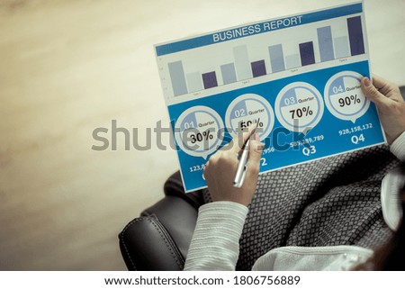 Asian business woman reviewing data in financial charts and graphs. Accounting