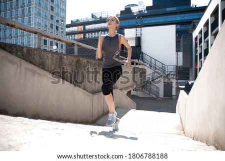 Portrait of a healthy young woman running outdoors.