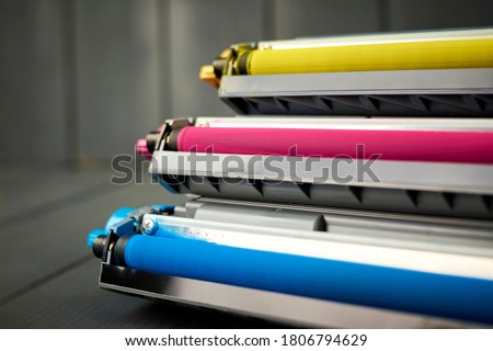 Toner replacement for cyan, magenta and yellow color laser printer on gray wooden background Royalty-Free Stock Photo #1806794629