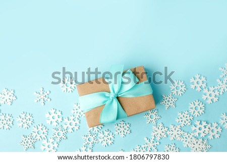 Happy New 2021 year concept, gift or present box with tissue bow and white snowflakes on blue background, copy space, xmas, christmas winter holiday creative card, banner, flyer, promotion voucher