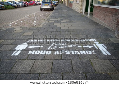 Drawing on pavement in Dutch letters means, 'We beat Corona together, this is 1.5 meters, keep your distance!' Coronavirus measures and rules for social distancing.