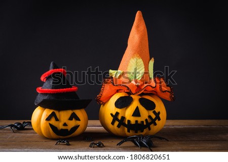 Funny Halloween day party concept ghost pumpkins head jack lantern scary smile wear hat and spider on wooden table and black background, studio shot isolated, Holiday decoration