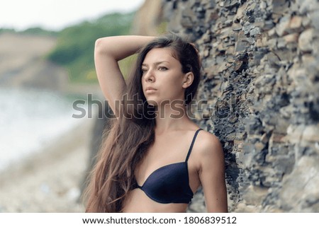 Beautiful brunette woman among the rocks.