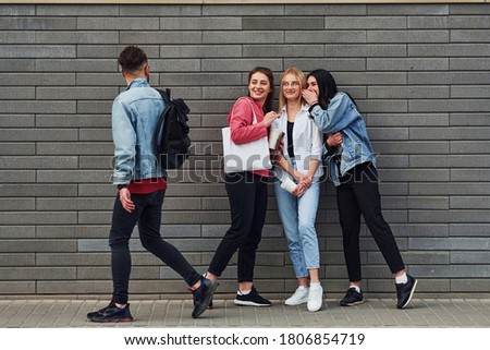 Three women and one guy is outdoors near building at daytime.