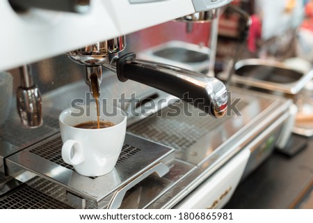 black coffee in white cup put on coffee maker