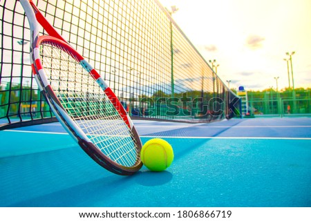 Tennis racket and ball on the blue-coated court Royalty-Free Stock Photo #1806866719