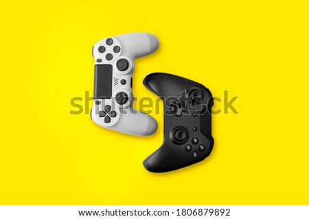 White and Black game controllers on yellow background