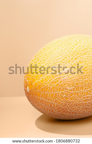 Sweet melon with balance slice on an autumn color background. Abstract minimalistic vertical photo with place for your text.