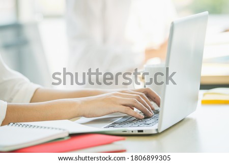Woman working in the office by using personal laptop computer close up, close up on a hands on computer keyboard. Office woman using laptop computer for sending an email and social media.