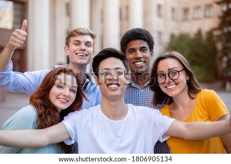 Cheerful Multicultural Students Posing Together Making Selfie Near University Building Outdoors. College Education Concept Royalty-Free Stock Photo #1806905134