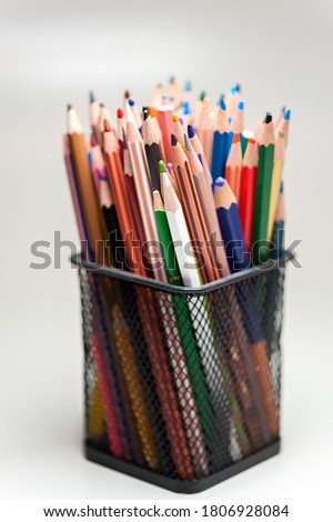The black holder with colorful pencils