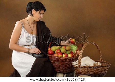 Young Romana with basket full of fruits and vegetables. Concept studio portrait on brown background.
