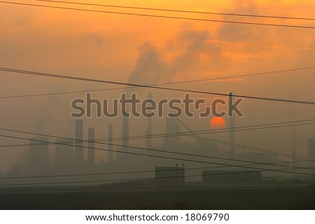 smoky factory at sunset
