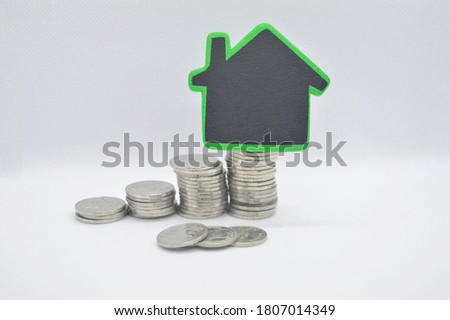 The coins are layered and some small, painted black with green border, in concept of saving money for having a house.