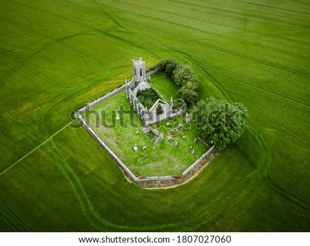 Aerial picture of Ballynafagh Church ruins & Graveyard in middle of green field