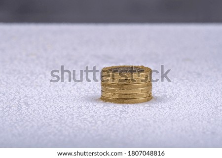 stack of coins on a white table with water drops