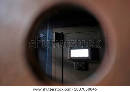 Prison jail solitary cell door locked on shadow area, view from hole behind the bars. Penitentiary cage concept of correctional punish imprisonment Royalty-Free Stock Photo #1807058845