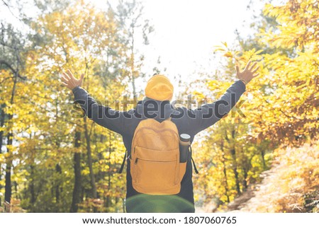 Young Man Wearing Yellow Backpack Hands Up in the Nature. Man Hiking in the Mountain. Lifestyle Concept.