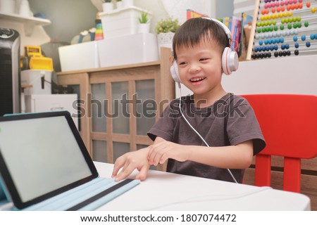 Asian 4 years old toddler boy child using tablet pc computer, Child at home, kindergarten closed during the Covid-19 health crisis, Distance Learning, Online Games, Activities for Kindergarten concept